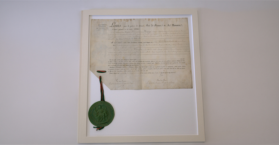 Bespoke museum-grade conservation mount housing an illustrated historical parchment document and its green wax seal.