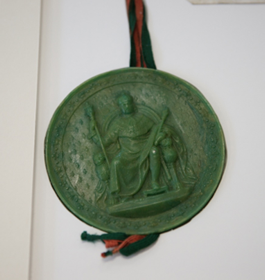 Detailed view of a well-preserved green wax seal suspended by red and green silk cords signifying perpetual validity.
