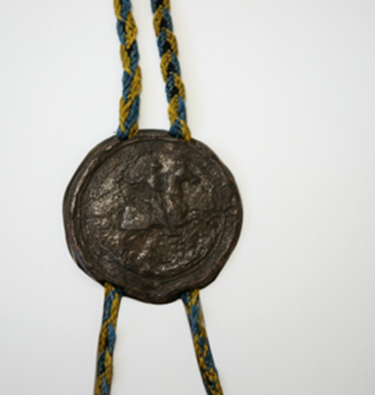 Close-up of a historic pendant seal secured with intricately braided blue and gold silk cords.<br />