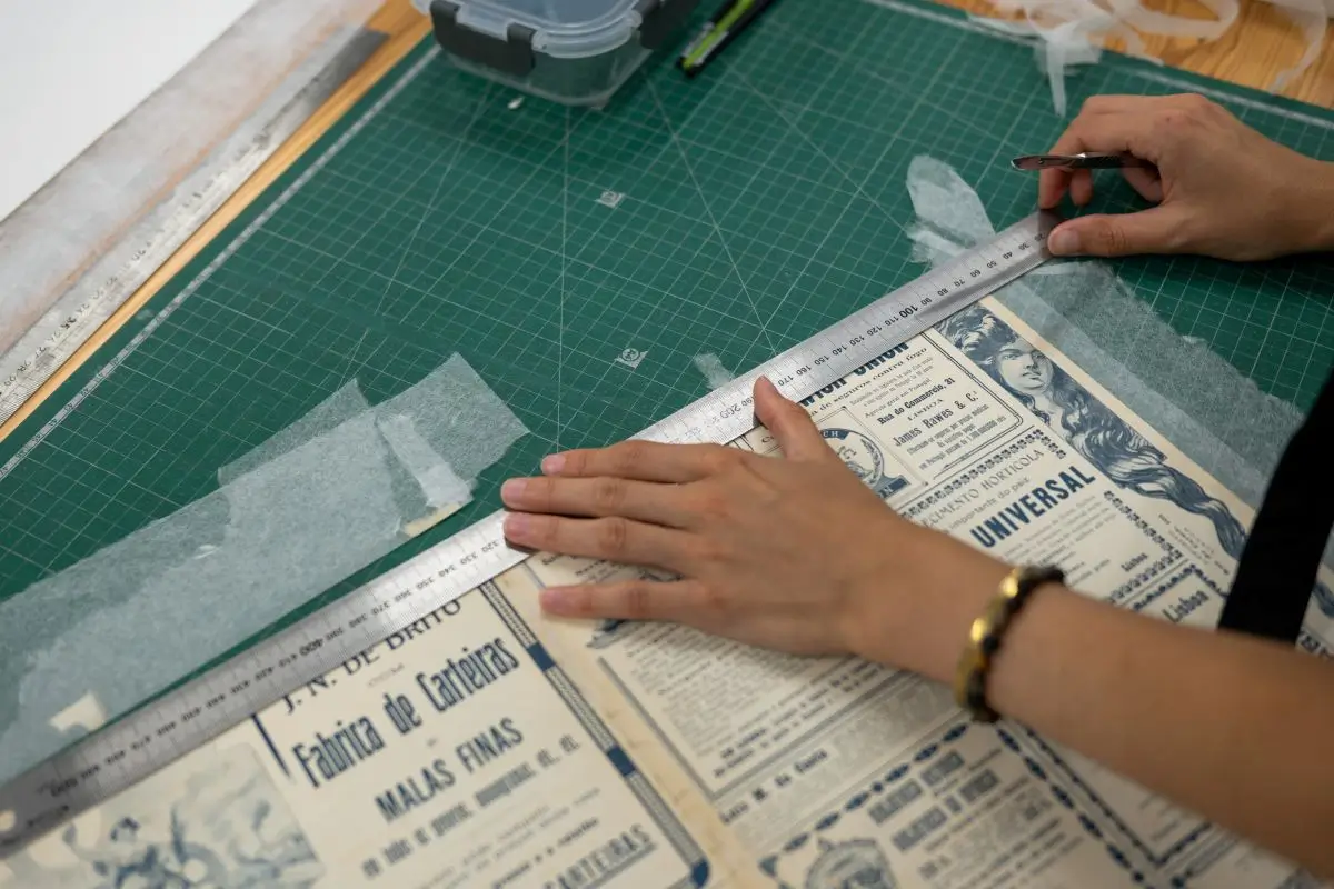 MEMORIST CFA apprentices and University of Coimbra conservators standing in a paper restoration studio.